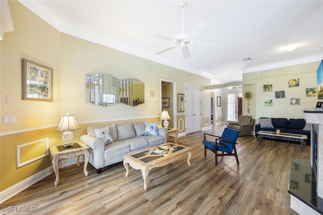 living room featuring a high end fireplace, crown molding, ceiling fan, and wood-type flooring