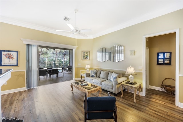 living room featuring wood-type flooring, ceiling fan, and crown molding