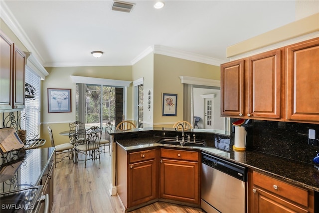 kitchen with dark stone countertops, crown molding, stainless steel dishwasher, and light wood-type flooring