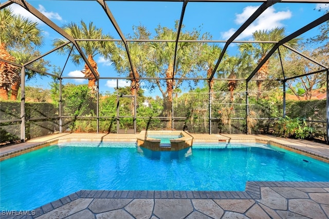 view of pool with a lanai and an in ground hot tub