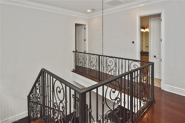 stairway with wood-type flooring and ornamental molding