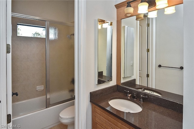 full bathroom featuring toilet, combined bath / shower with glass door, and vanity