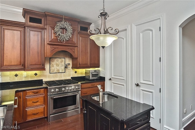 kitchen featuring backsplash, high end stainless steel range oven, a kitchen island with sink, sink, and dark hardwood / wood-style floors