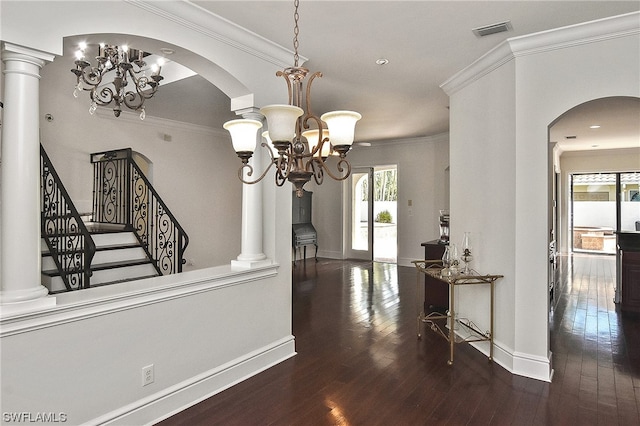 hall featuring ornamental molding, dark wood-type flooring, and an inviting chandelier