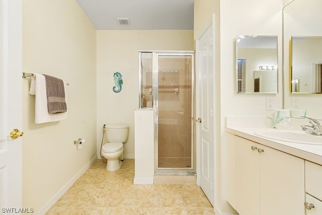 bathroom featuring tile patterned flooring, vanity, toilet, and a shower with door