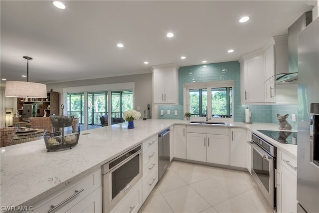 kitchen featuring white cabinets, light stone countertops, appliances with stainless steel finishes, and sink