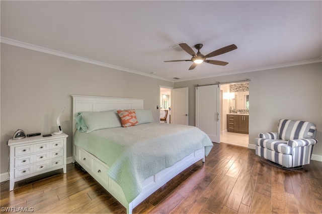 bedroom with ensuite bath, ceiling fan, crown molding, dark hardwood / wood-style flooring, and a barn door