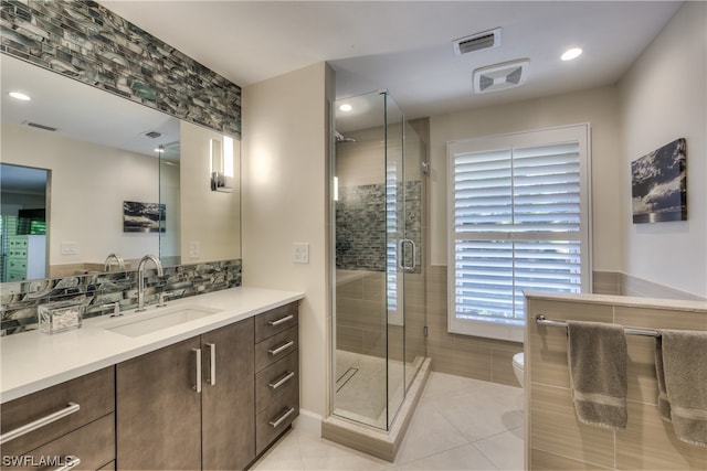 bathroom featuring vanity, tile floors, a shower with shower door, and toilet