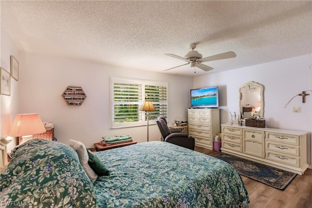 bedroom featuring hardwood / wood-style floors, a textured ceiling, and ceiling fan