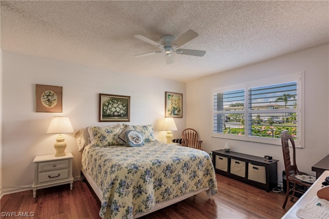 bedroom with a textured ceiling, ceiling fan, and dark hardwood / wood-style floors