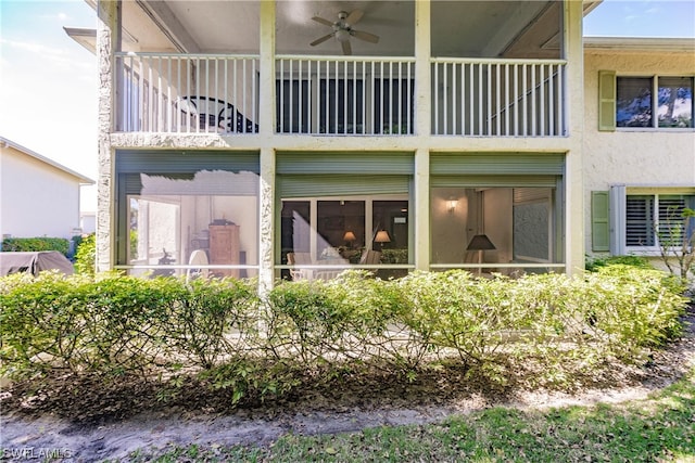 rear view of property featuring a balcony and ceiling fan