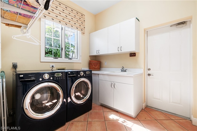 laundry area featuring cabinets, sink, light tile patterned floors, and washer and clothes dryer