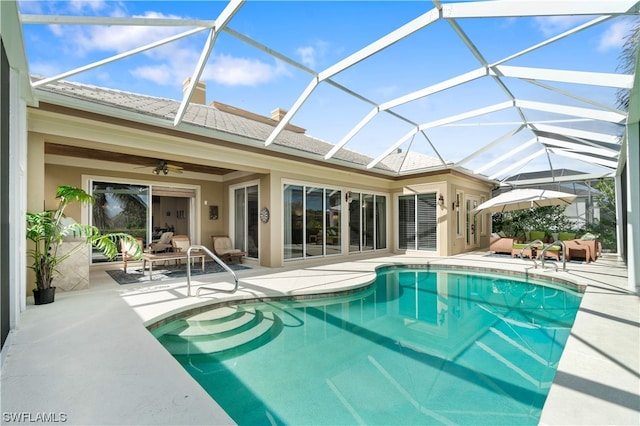 view of pool with ceiling fan, a patio area, and a lanai