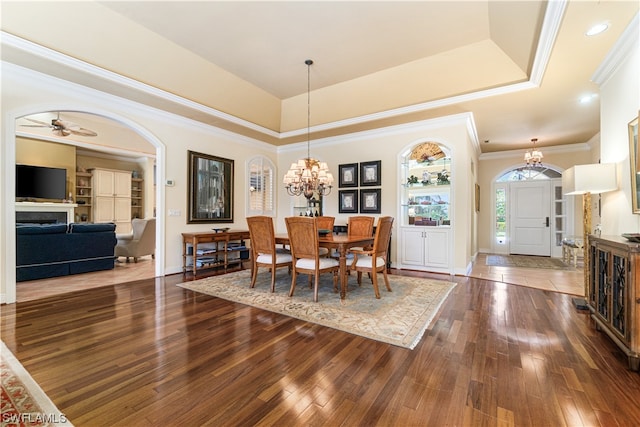 dining space with crown molding, dark hardwood / wood-style floors, and a raised ceiling