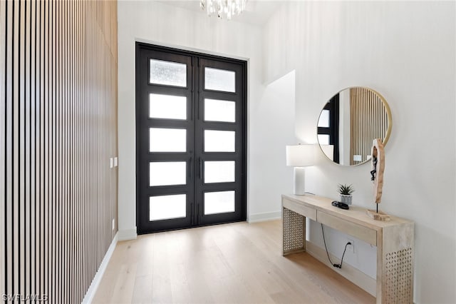 foyer entrance with light hardwood / wood-style floors and a notable chandelier