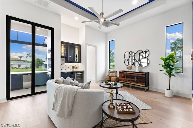 living room featuring beverage cooler, ceiling fan, and light hardwood / wood-style flooring