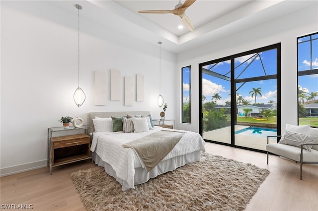 bedroom with wood-type flooring, ceiling fan, and access to exterior