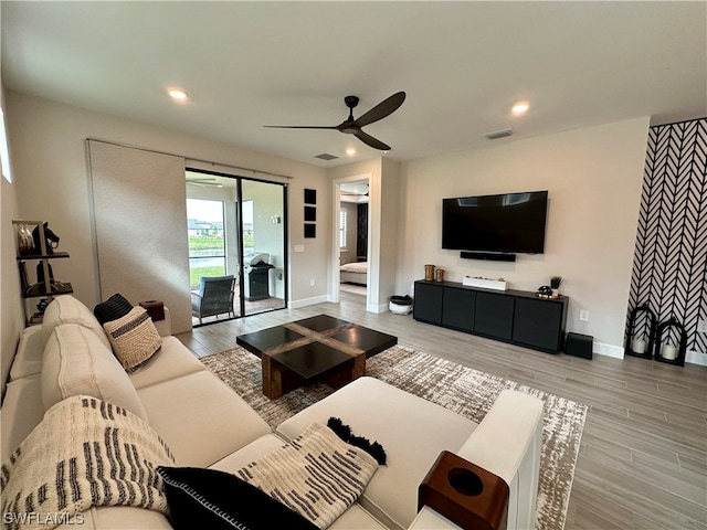 living room featuring light hardwood / wood-style floors and ceiling fan