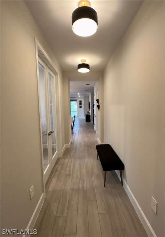 corridor featuring french doors and wood-type flooring