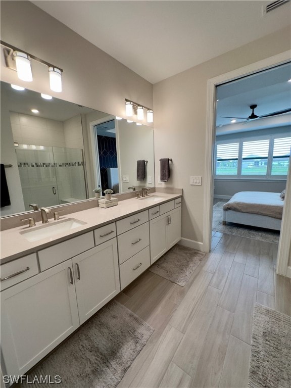 bathroom with walk in shower, dual bowl vanity, and ceiling fan