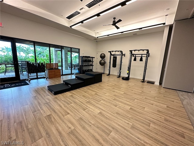 exercise area featuring french doors, ceiling fan, and light wood-type flooring