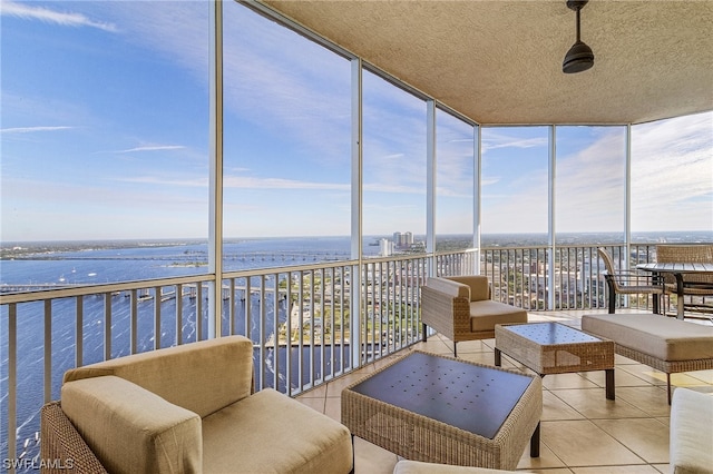 sunroom featuring a water view