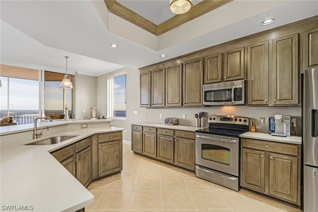 kitchen featuring sink, appliances with stainless steel finishes, hanging light fixtures, and a healthy amount of sunlight