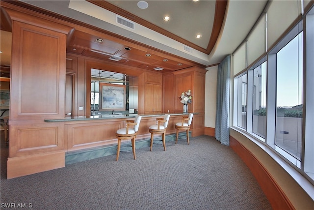 bar featuring a raised ceiling, carpet floors, and ornamental molding