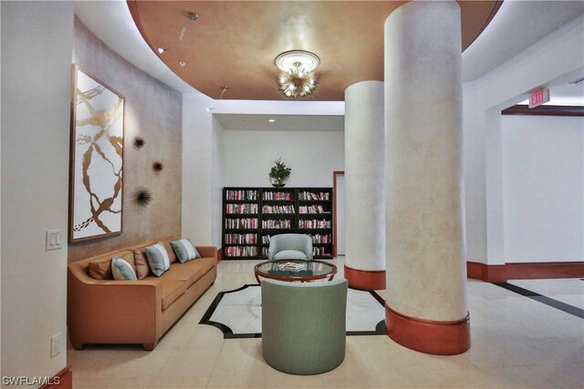 interior space featuring light tile flooring, decorative columns, and an inviting chandelier