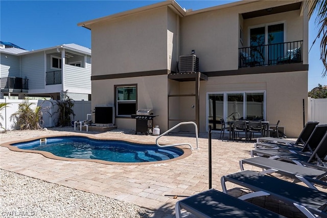 view of pool with central AC, grilling area, and a patio area