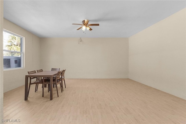 dining area with light wood-type flooring and ceiling fan