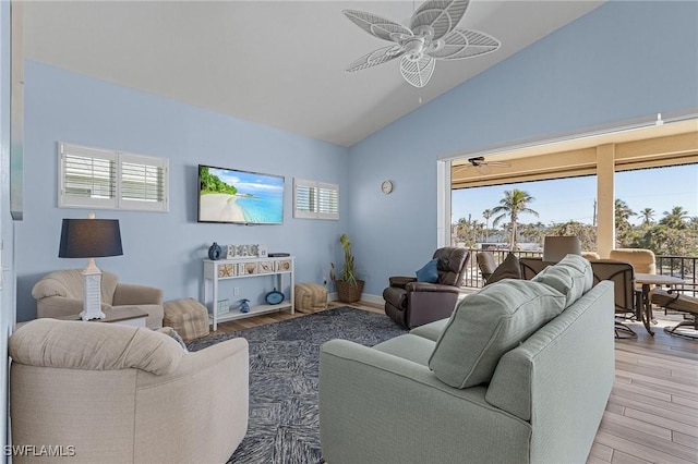 living room with a healthy amount of sunlight, light hardwood / wood-style floors, and vaulted ceiling