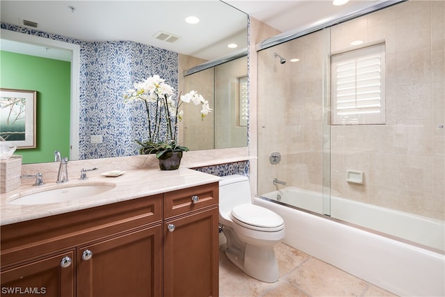 full bathroom with vanity, shower / bath combination with glass door, and toilet