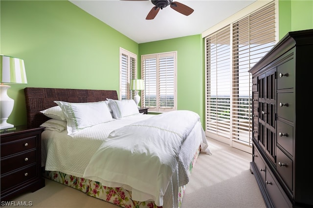 bedroom with access to outside, light colored carpet, and ceiling fan