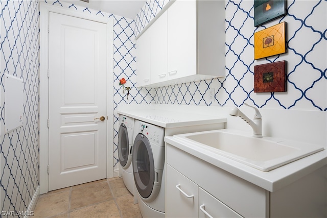 laundry area with sink, washing machine and dryer, and cabinets