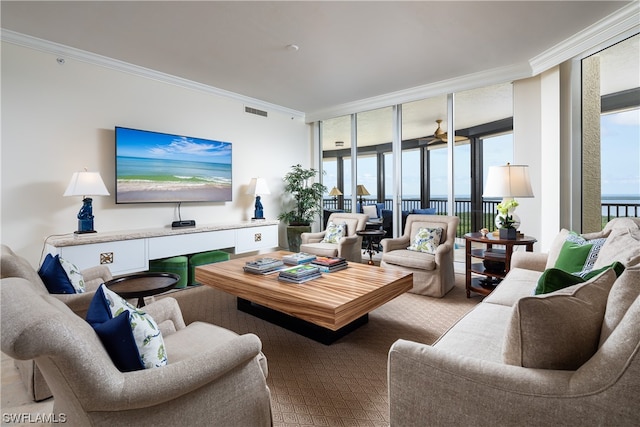 living room with a water view, ornamental molding, and expansive windows