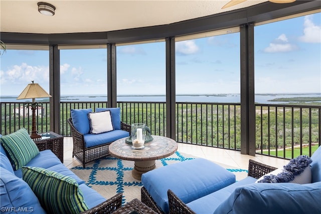 sunroom featuring a water view