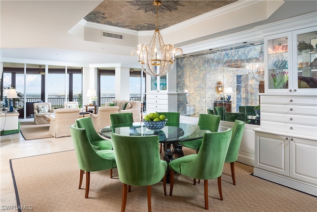 dining room with light tile patterned flooring, an inviting chandelier, tile walls, ornamental molding, and a tray ceiling