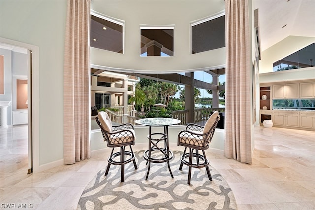 interior space featuring light tile floors and a towering ceiling