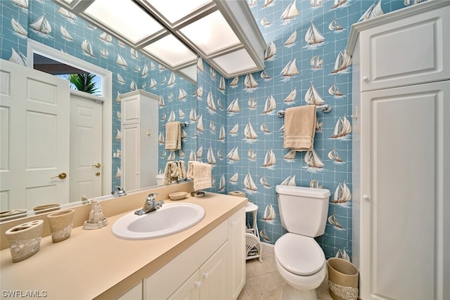 bathroom with toilet, tile flooring, vanity, and tile walls