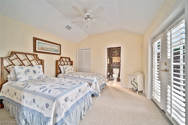 bedroom featuring a closet, ceiling fan, connected bathroom, vaulted ceiling, and light colored carpet