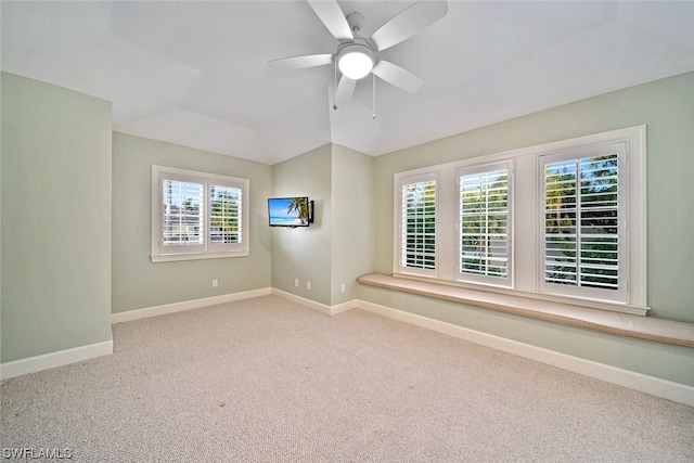 spare room with lofted ceiling, light colored carpet, and ceiling fan