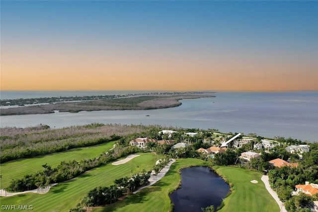 aerial view at dusk featuring a water view