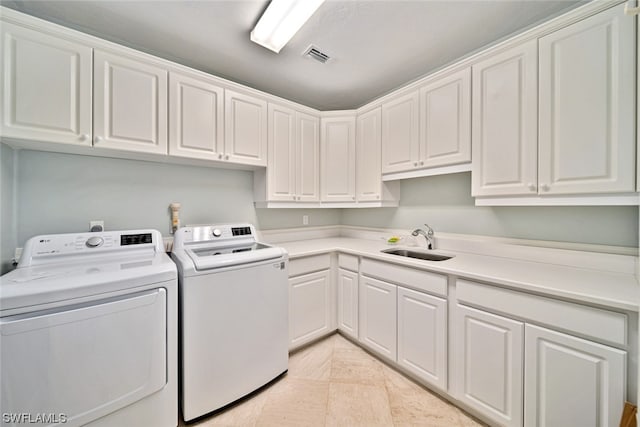 clothes washing area featuring washer and dryer, cabinets, sink, and light tile floors