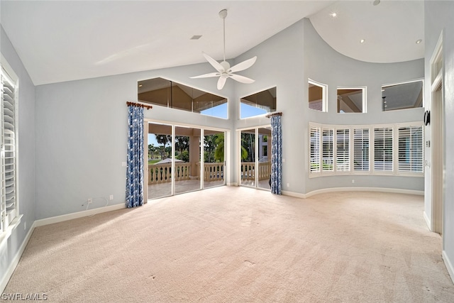 spare room featuring light carpet, a healthy amount of sunlight, ceiling fan, and high vaulted ceiling