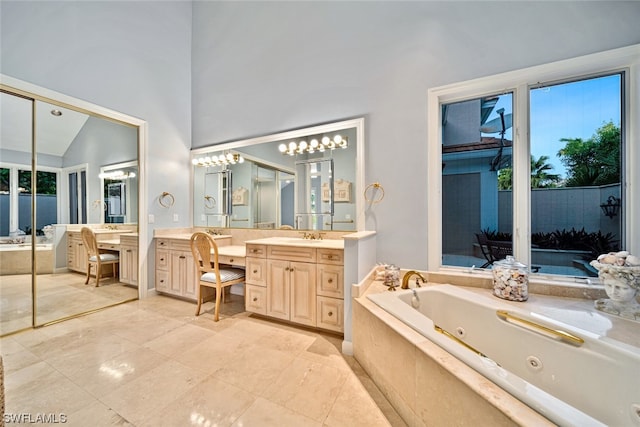 bathroom featuring tiled bath, tile floors, vanity, and a high ceiling