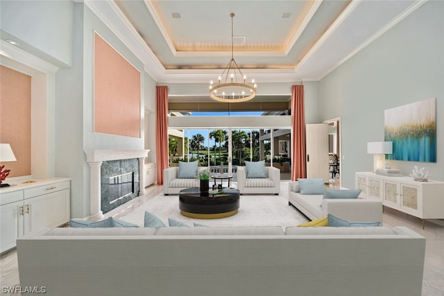 tiled living room with a chandelier, a tray ceiling, and a fireplace