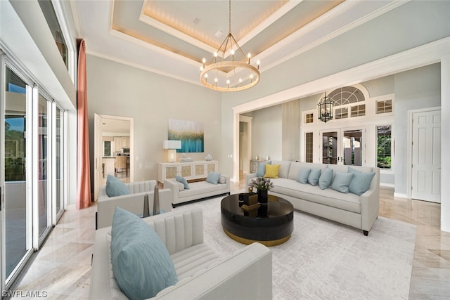 tiled living room featuring crown molding, a notable chandelier, a tray ceiling, and a high ceiling