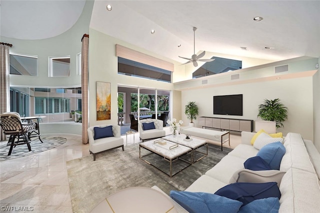 living room featuring tile floors, ceiling fan, and a high ceiling