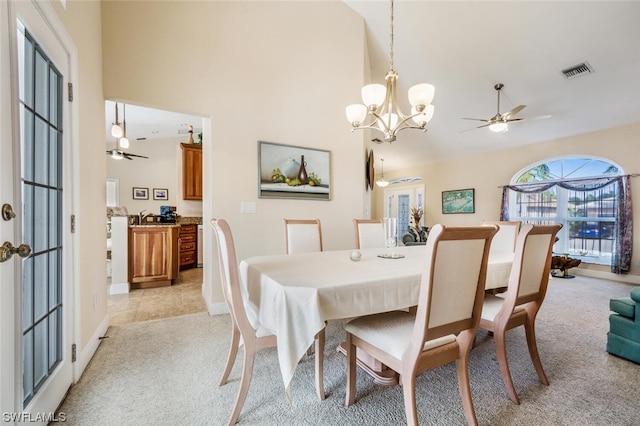 dining area with light tile floors, high vaulted ceiling, and ceiling fan with notable chandelier